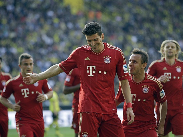 Bayern's Mario Gomez is congratulated by team mates after scoring the equaliser against Dortmund on May 4, 2013