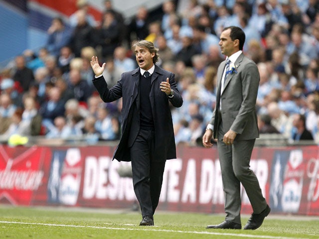 Wigan Athletic manager Roberto Martinez and Manchester City manager Roberto Mancini on the touchline during the FA Cup Final on May 11, 2013