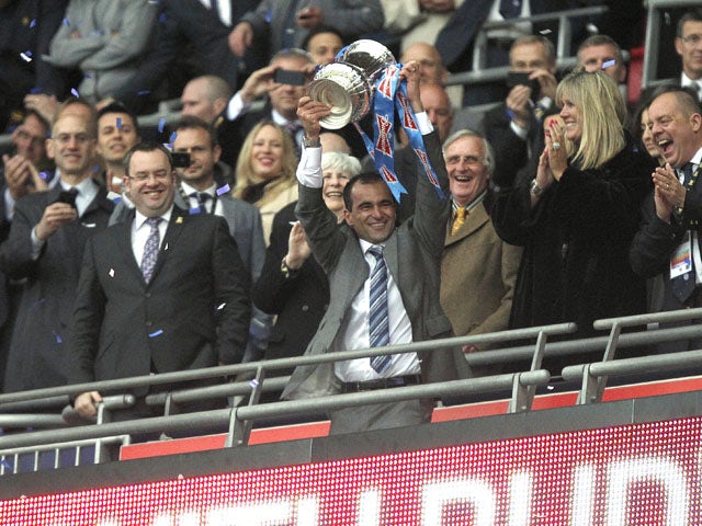 Wigan Athletic manager Roberto Martinez lifts the FA Cup trophy after his side's victory over Manchester City on May 11, 2013