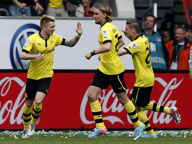 Dortmund's Marco Reus celebrates scoring his side's third goal against Wolfsburg on May 11, 2013