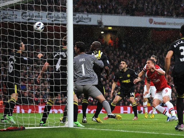 Arsenal forward Lukas Podolski scores against Wigan on May 14, 2013