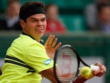 Milos Raonic returns the ball to Michael Llodra during their second round match of the French Open on May 29, 2013