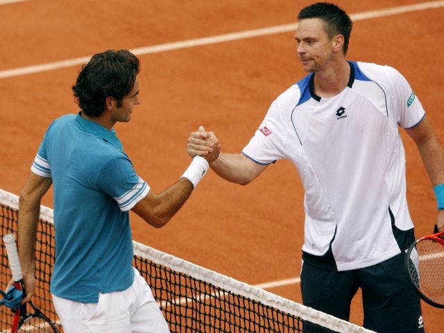 Roger Federer and Robin Soderling meet at the net after their French Open clash.