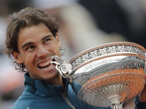 Spain's Rafael Nadal bites the trophy after beating compatriot David Ferrer in the French Open final on June 9, 2013
