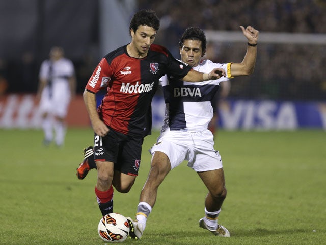 Ignacio Scocco of Argentina's Newell's Old Boys vies for the ball with Walter Erviti of Argentina's Boca Juniors on May 29, 2013