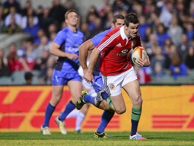 The British and Irish Lions' Jonathon Sexton runs his way to scoring a try during their rugby union tour match against the Force on June 5, 2013