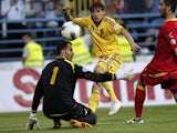 Ukraine's Denys Garmash scores past Montenegro's goalkeeper Mladen Bozovic during their World Cup qualifying match on June 7, 2013