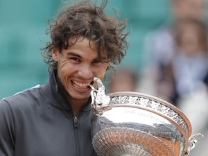 Rafael Nadal bites the French Open trophy.
