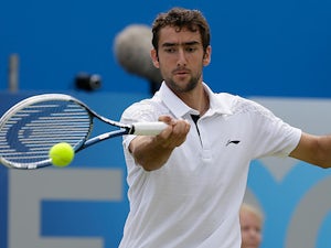 Marin Cilic returns the ball to Tomas Berdych during their quarter final match at Queens on June 14, 2013