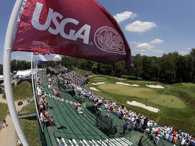Spectators watch golfers on the 17th green during practice for the U.S. Open golf tournament at Merion Golf Club on June 12, 2013