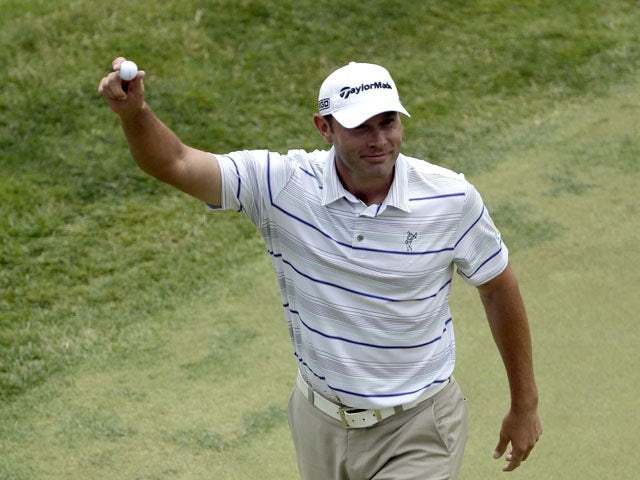 Shawn Stefani shows off the ball to the gallery after hitting a hole in one on the 17th hole during the fourth round of the U.S. Open golf tournament on June 16, 2013