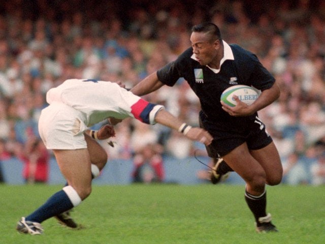 Jonah Lomu holds of a challenge from an England player.