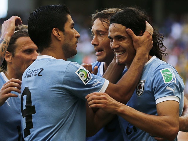 Uruguay's Edinson Cavani is congratulated by team mates after scoring his first goal against Italy during the Confederations Cup on June 30, 2013