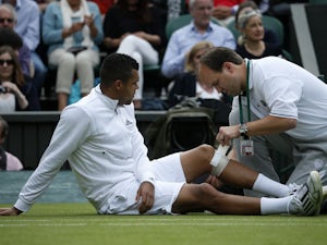 France's Jo-Wilfried Tsonga receives treatment in his match against Latvia's Ernests Gulbis during their second round match at Wimbledon on June 26, 2013