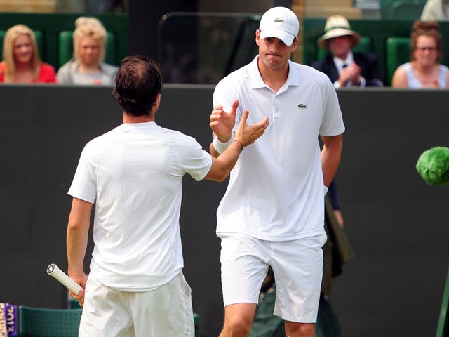 USA's John Isner shakes hands with France's Adrian Mannarino after retiring from the match during day Three of the Wimbledon Championships on June 26, 2013