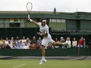 Juan Monaco of Argentina looks over his shoulder to track the trajectory of a lob by Rajeev Ram of the United States during their Men's second round singles match on June 26, 2013
