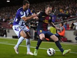 Valladolid's Mikel Balenziaga tries to tackle Barcelona's Andres Iniesta during the La Liga clash on May 19, 2013
