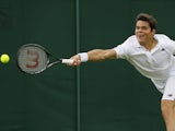 Milos Raonic of Canada plays a return to Carlos Berlocq of Argentina during their Men's first round singles match on June 25, 2013