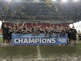 New Zealand's All Blacks celebrate with their men and women trophies after winning both at the Rugby Sevens World Cup on June 30, 2013