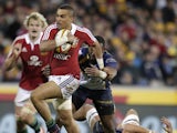 British and Irish Lions player Simon Zebo breaks through the tackle of ACT Brumbies' players Jordan Smiler during the tour match on June 18, 2013