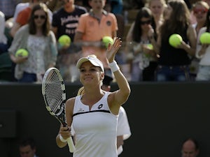 Agnieszka Radwanska waves to the crowd as she celebrates her win over Tsvetana Pironkova during their Wimbledon match on July 1, 2013
