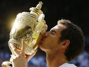 Andy Murray of Britain poses with the Wimbledon trophy after defeating Novak Djokovic of Serbia during the Men's singles final on July 7, 2013