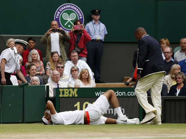 Argentina's Juan Martin Del Potro rolls on the ground in pain during his match against Spain's David Ferrer during day nine of the Wimbledon Tennis Championships on July 3, 2013