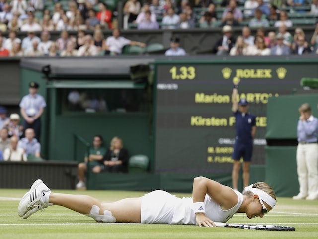 Kirsten Flipkens lays on the ground after losing a point to Marion Bartoli on July 4, 2013