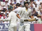 Australia's Ashton Agar smiles as he passes fellow batsman Phillip Hughes as the pair surpass the record for a 10th wicket Test partnership on day two of the first Ashes Test on July 11, 2013