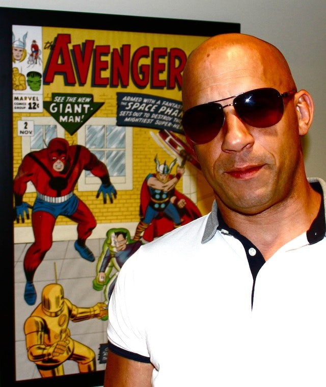 Vin Diesel standing in front of a Marvel poster (640w)