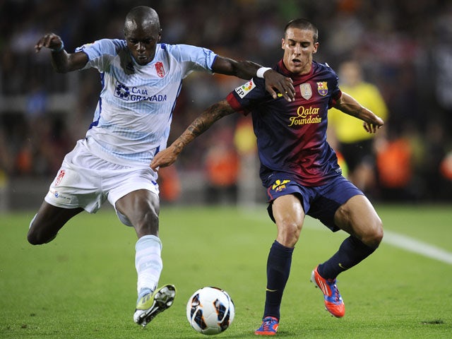 Granada's Allan Nyom battles with Barcelona's Tello during the LA Liga match on September 22, 2012