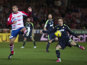 Granada's Carlos Aranda jumps to block a shot from Real Madrid's Luka Modric during the La Liga match on February 2, 2013