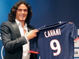 New Paris Saint Germain signing Edinson Cavani poses with his new team's shirt during a press conference on July 16, 2013