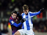 Real Sociedad's Antoine Griezmann challenges for the ball with FC Barcelona's Cuenca during the match on February 4, 2012
