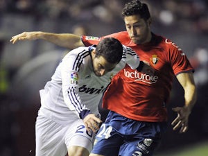 Osasuna's Damia Abella duels with Real Madrid's Gonzalo Higuain during the La Liga match on January 12, 2013