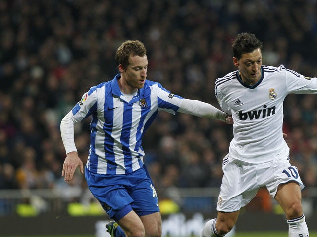 Real Sociedad's David Zurutuza vies for the ball with Real Madrid's Mesut Ozil during the La Liga clash on January 6, 2013