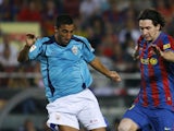 Almeria's Hernan Bernardello vies for the ball with Barcelona's Lionel Messi on October 3, 2009