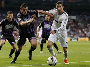 Valladolid's Jesus Rueda vies for the ball with Real Madrid's Cristiano Ronaldo during the La Liga match on May 4, 2013 