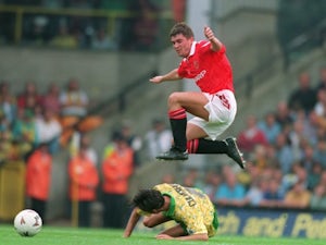 Roy Keane leaps over a Norwich City midfielder at Carrow Road.