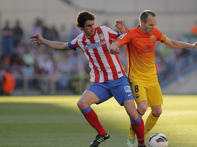 Atletico Madrid's Tiago Mendes attempts to tackle FC Barcelona's Andres Iniesta during the La Liga match on May 12, 2013