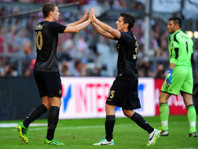 Manchester City's Edin Dzeko celebrates scoring his first goal with team mate Stevan Jovetic on July 31, 2013