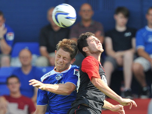 Huddersfield Town's Cristian Lopez out jumps Oldham Athletic's James Tarkowski during a friendly match on May 27, 2013