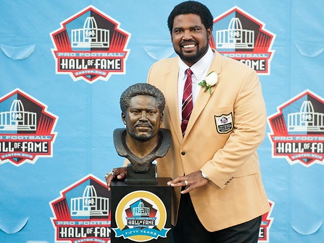 Former Baltimore Ravens' Jonathan Ogden poses with his Hall of Fame bust at the NFL Class of 2013 Enshrinement Ceremony on August 3, 2013