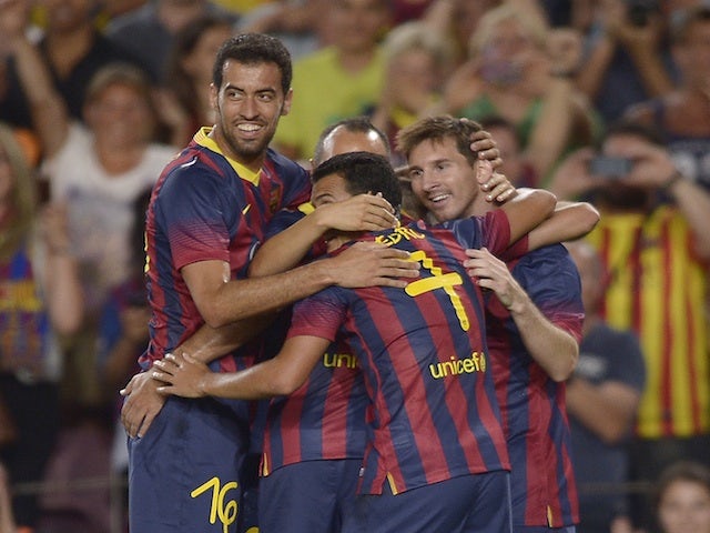 Barcelona's Lionel Messi celebrates with teammates on August 2, 2013