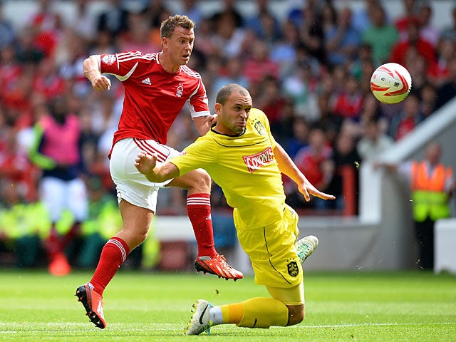 Forest's Simon Cox shoots past Huddersfield's Joel Lynch on August 3, 2013