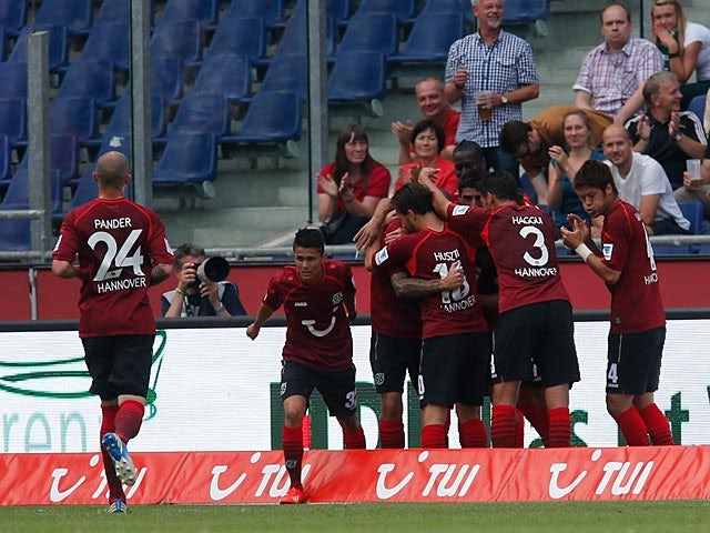 Hannover's Leon Andreasen is mobbed by his team mates after scoring the opening goal against Wolfsburg on August 10, 2013