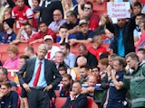 Arsene Wenger of Arsenal looks on as a fan behind makes his feelings known during the Barclays Premier League match between Arsenal and Aston Villa at Emirates Stadium on August 17, 2013