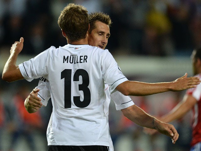 German striker Miroslav Klose and German midfielder Thomas Mueller celebrate scoring during the friendly football match Germany vs Paraguay on August 14, 2013
