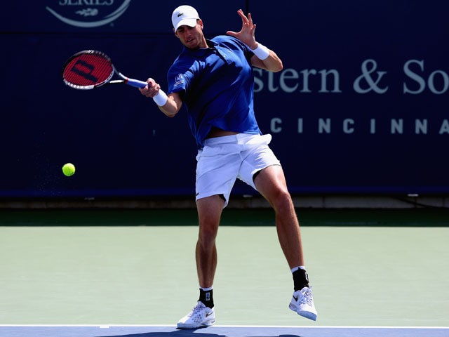 John Isner returns a shot to Milos Raonic of Canada during the Western & Southern Open on August 15, 2013
