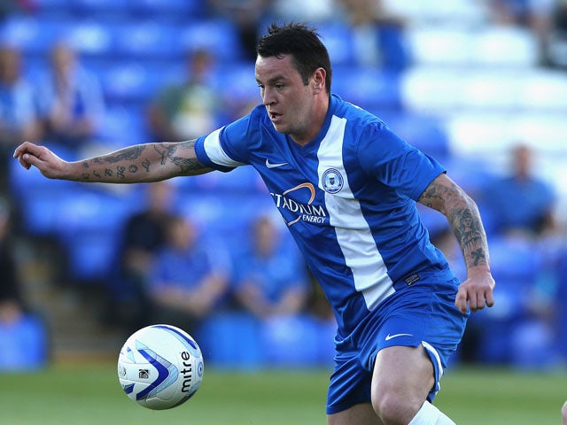 Lee Tomlin of Peterborough United runs with the ball during the pre season friendly match between Peterborough United and Hull City at London Road Stadium on July 29, 2013